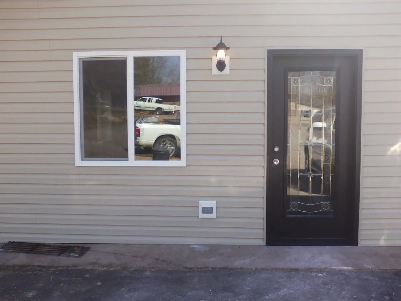 New siding, window and entry door on the side of an addition in Clyde