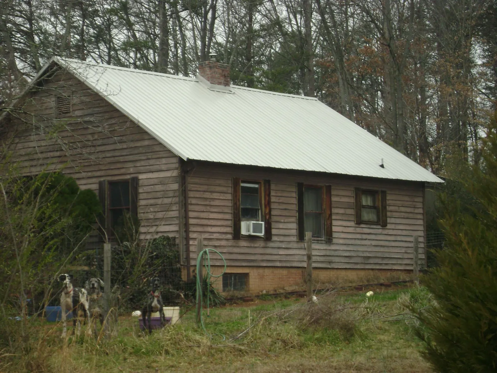 White metal roof on an old wood sided farmhouse, from a Metal Roof Installation job in Clyde